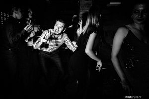 A black and white photo of people dancing and celebrating at a nighttime party.