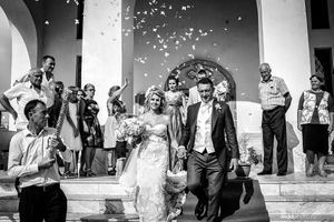 Wedding guests shower newlyweds with confetti on church steps.