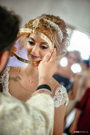Ornate bridal accessories include a golden headpiece and delicate lace details.