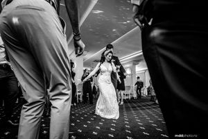 Black and white wedding reception photo showing a dance floor celebration with guests.