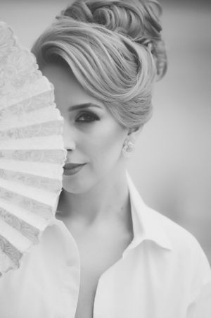 Vintage-inspired black and white portrait with a decorative paper fan.