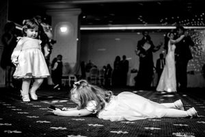 Black and white candid shot of playful wedding reception dance floor moments.