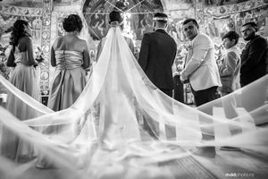 A dramatic black and white photo of a bride's flowing cathedral veil during a church ceremony.