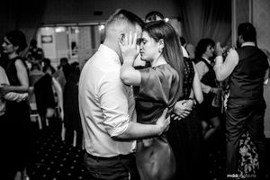 Couples dancing together at a formal event in black and white photography.