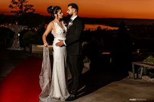 Romantic sunset portrait on a terrace with dramatic orange sky backdrop.