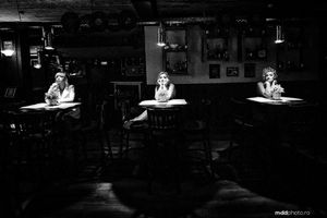 Three spotlit tables in a dark restaurant creating dramatic lighting and atmosphere.