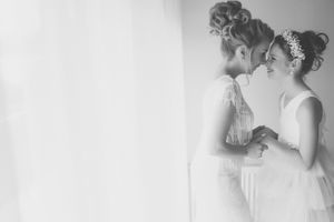 Black and white artistic photograph showing two bridal figures in soft focus.