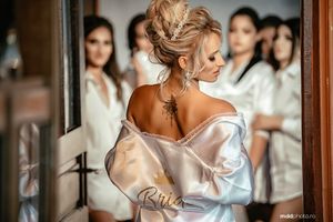 A getting ready moment captured in the mirror showing a silk robe and elegant hairstyle.