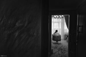 A silhouette seen through a doorway sitting in a quiet, contemplative moment.