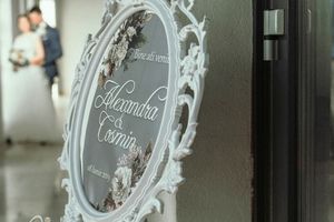 Elegant ornate mirror frame with decorative text for a wedding.
