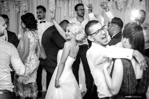Black and white photo of wedding reception dance floor with guests celebrating.