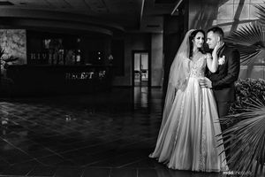 Two pairs of wedding shoes arranged on wooden platforms with dramatic lighting.