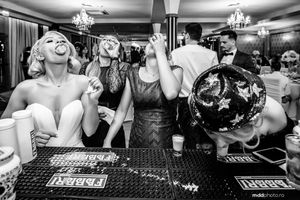 Black and white candid shot of lively party scene at bar counter.