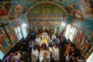 Overhead view of orthodox church wedding ceremony with ornate painted ceiling and gathered congregation.