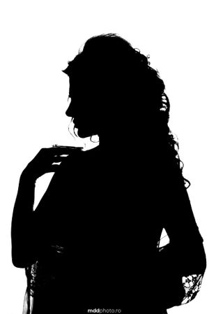 Artistic silhouette profile of woman with curly hair against light background.