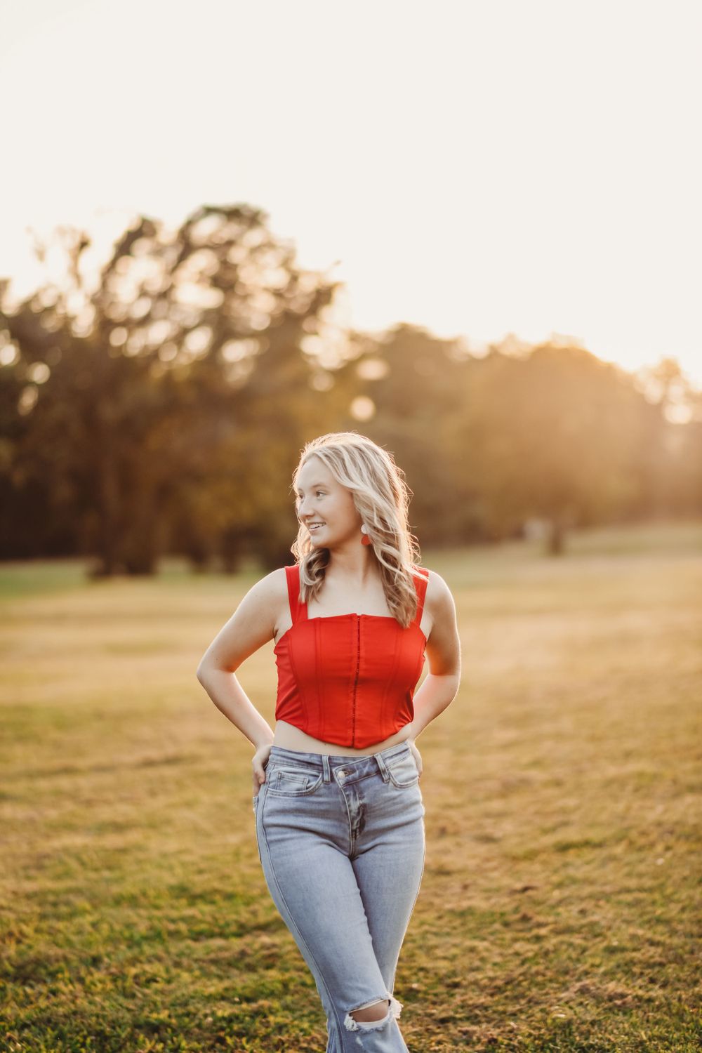 Golden hour portrait session in open field with warm sunset lighting.