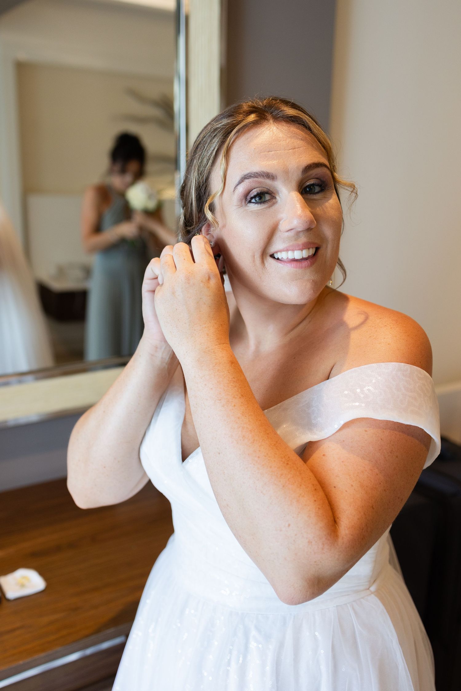 Bride putting her earrings in before wedding