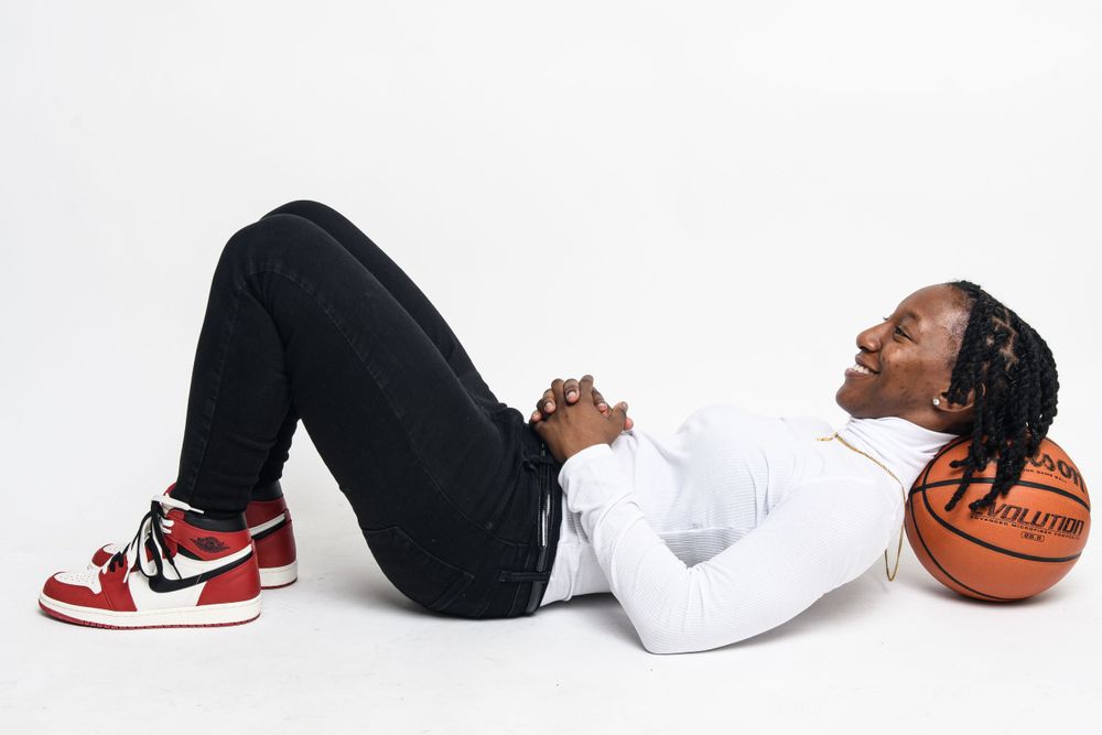 A basketball player lying on the floor next to a ball wearing Nike Air Jordan sneakers.