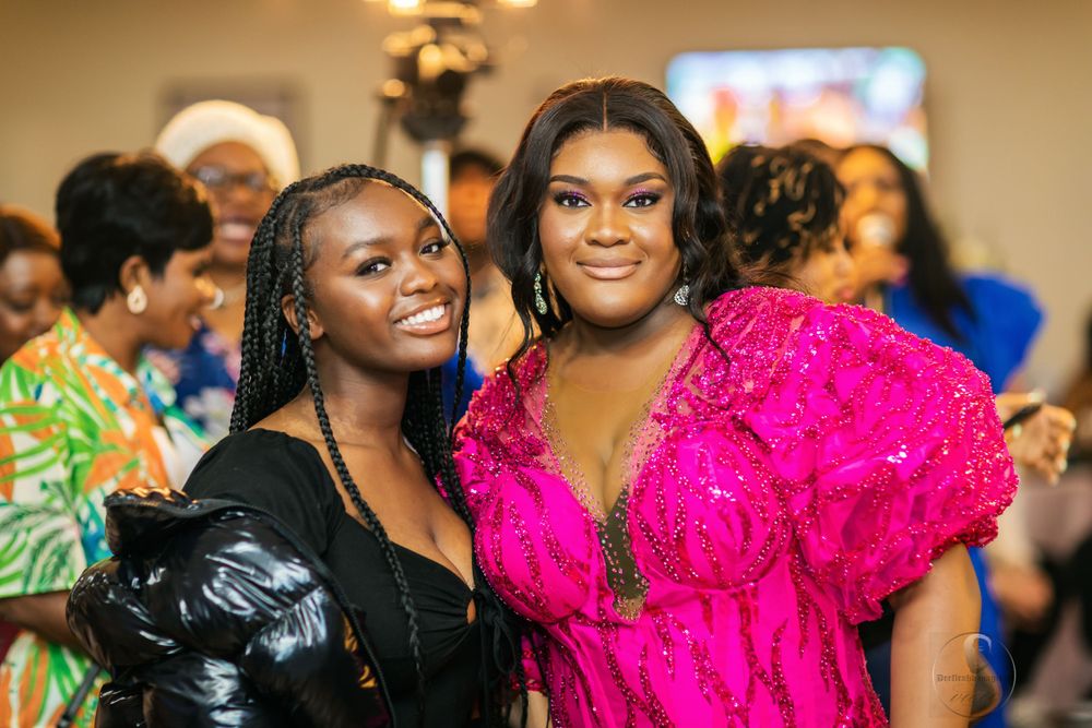 Two guests in formal attire pose together at an elegant celebration event.