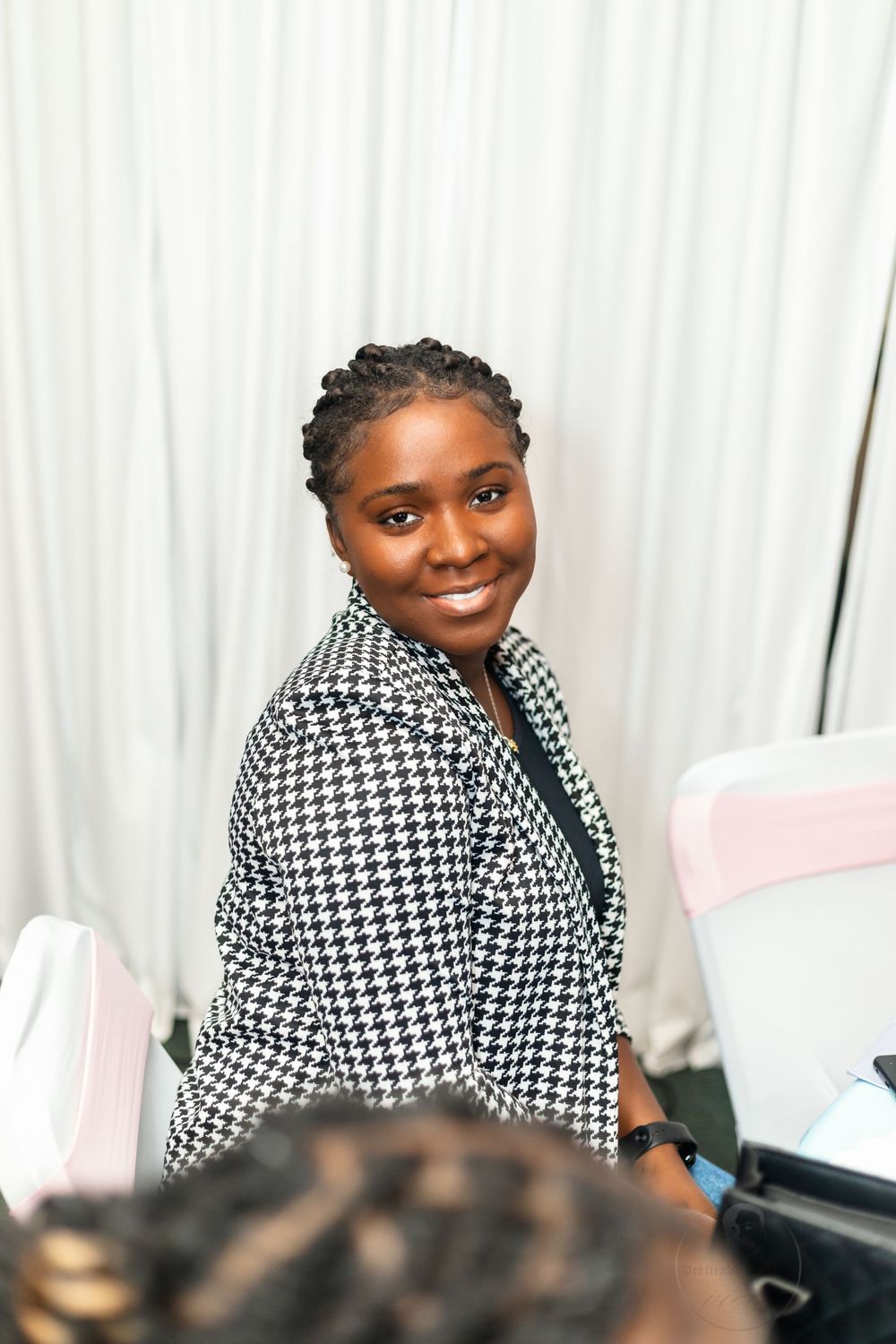 Guest smiles warmly wearing a stylish houndstooth blazer at celebratory event.