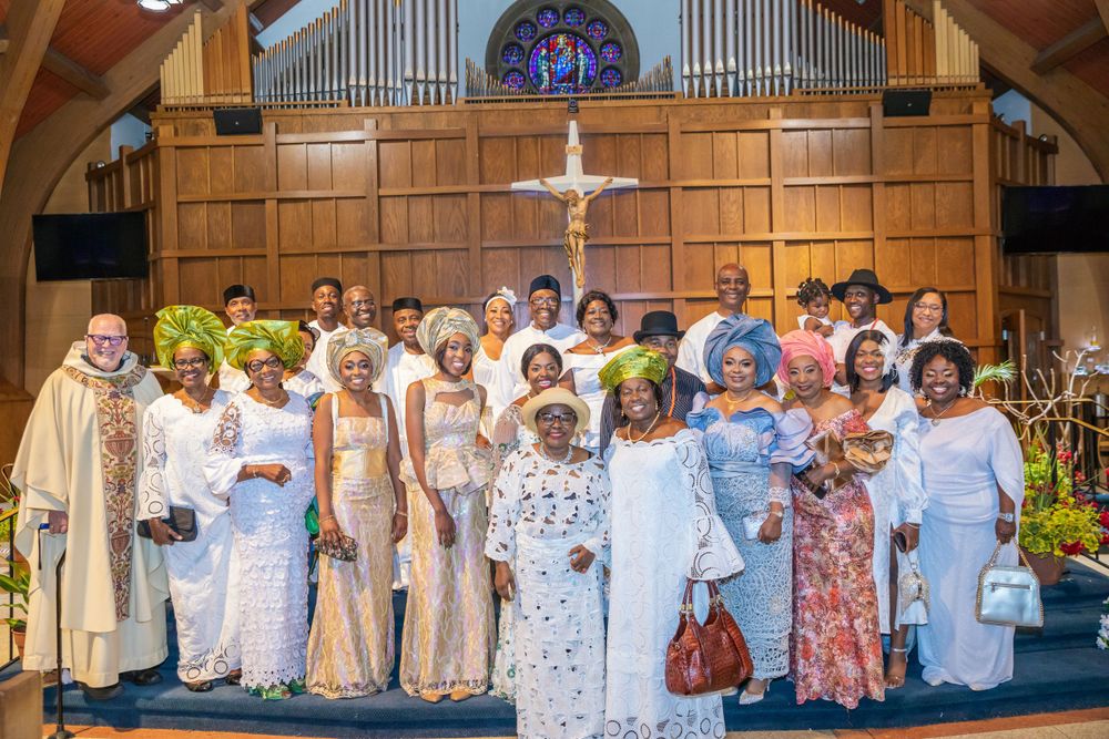 Large group photo of church congregation members in white and pastel formal attire.