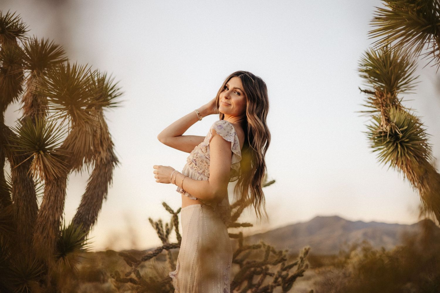 Desert photoshoot featuring soft lighting and Joshua trees in background.