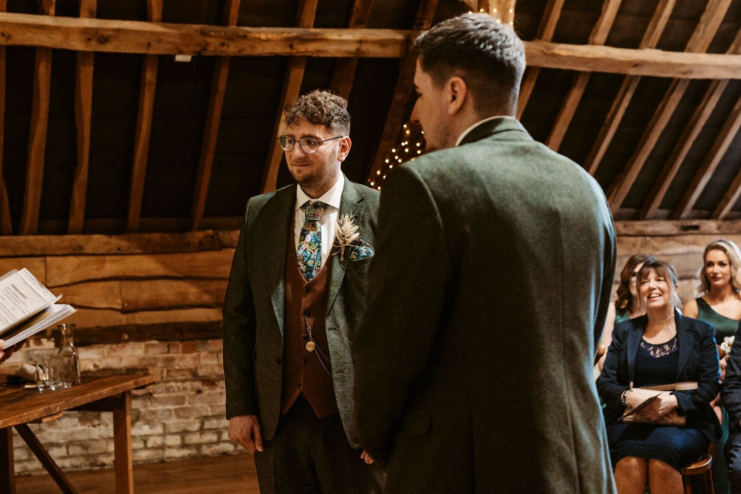 An intimate wedding ceremony moment in a rustic barn venue.