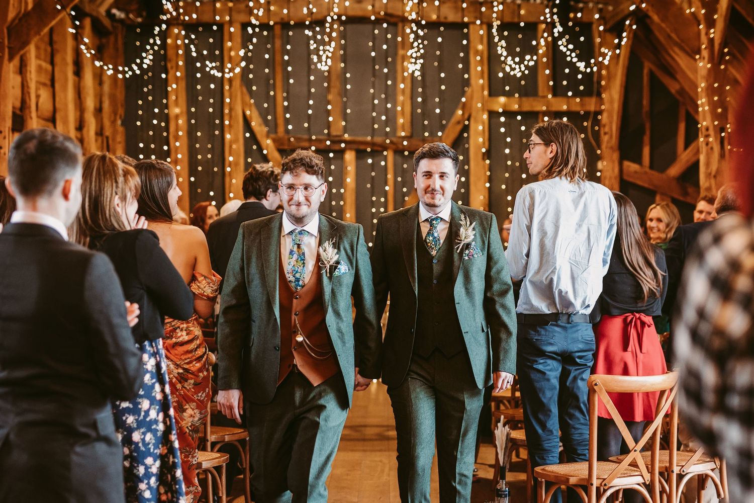 Wedding celebration in a barn venue decorated with string lights and rustic wooden details.