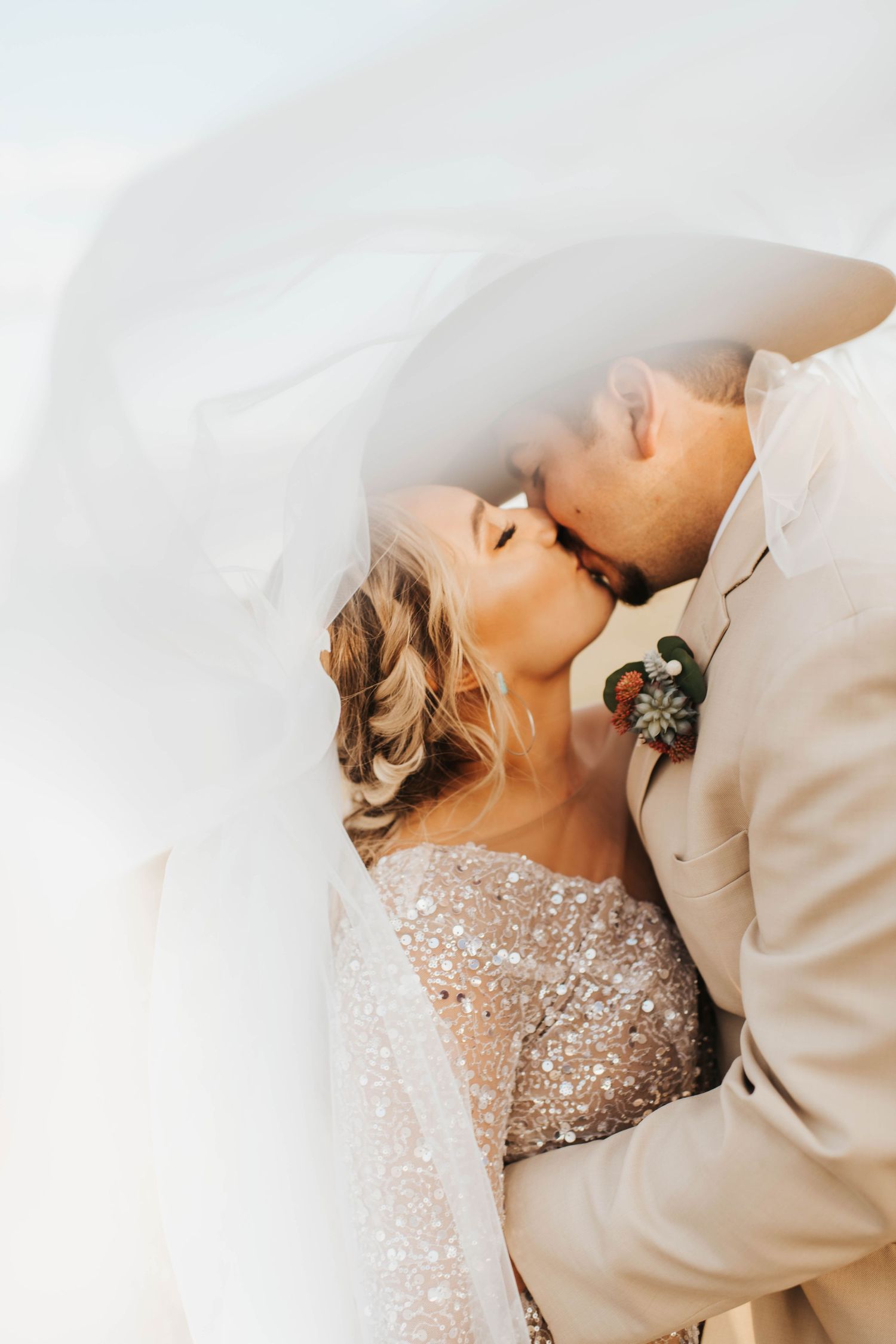 Couple kissing under a wedding veil