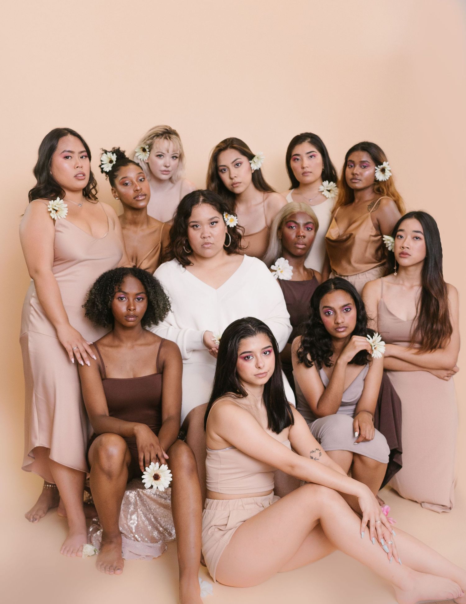 12 BIWOC, femmes and nonbinary folks dressed in brown, pink nudes, white dresses for Let's Love More photoshoot campaign