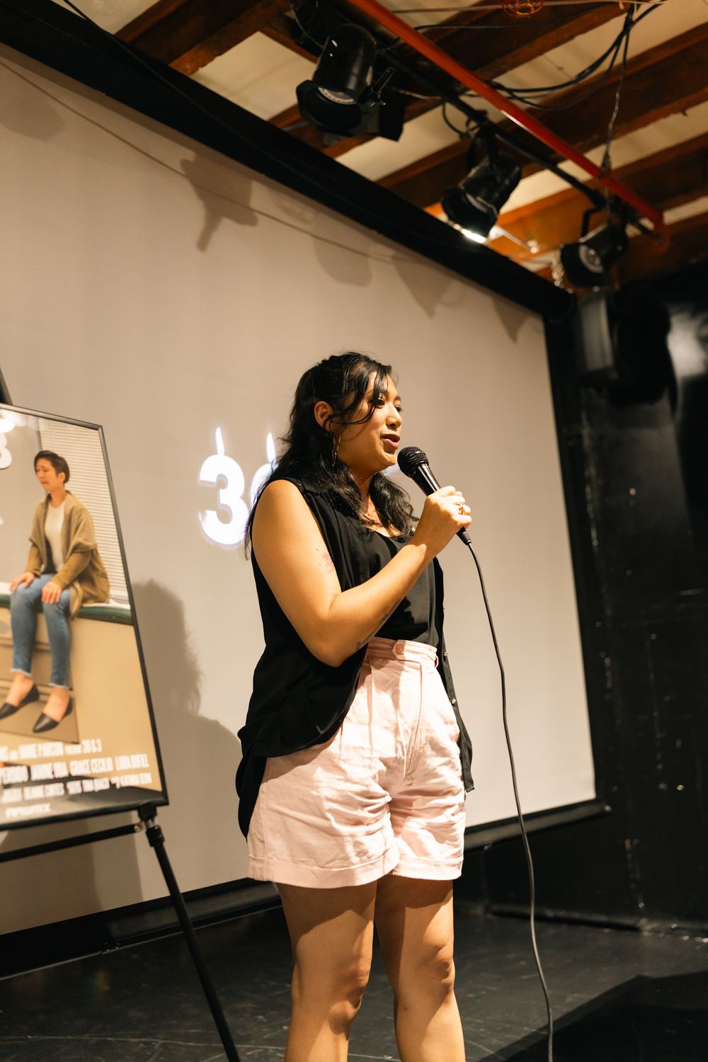 Stage performance with dramatic lighting and projected visuals in intimate theater setting.