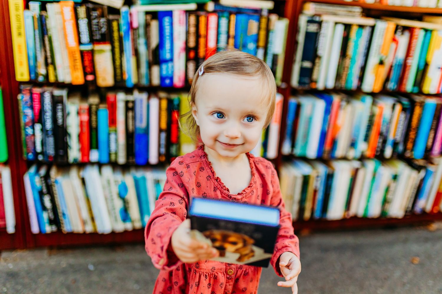 Sweet toddler holds puppy book during family photography session in downtown La Jolla.