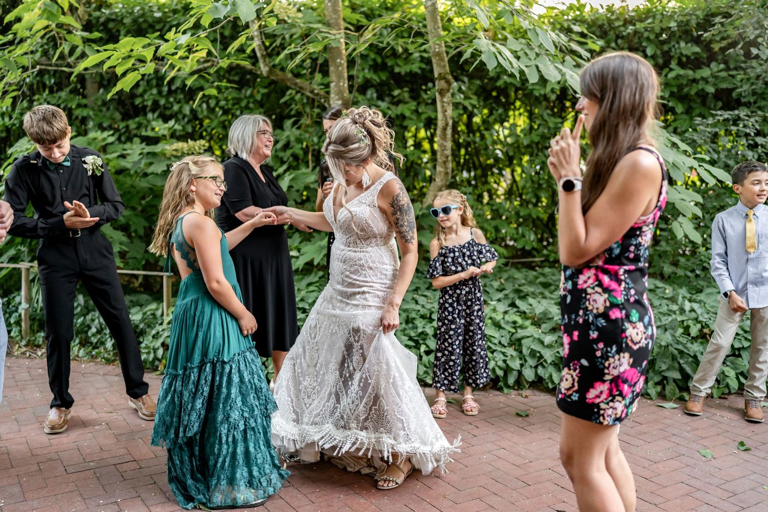 Guests dancing on a brick patio during an outdoor wedding celebration.