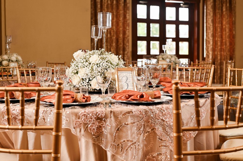 Formal wedding reception table with lace tablecloth, chiavari chairs and white floral centerpiece.