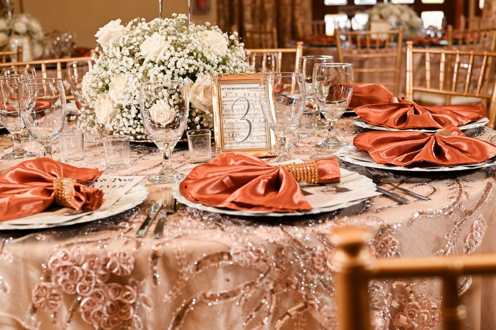 Elegant table setting with coral napkins, crystal glasses and white floral centerpieces.