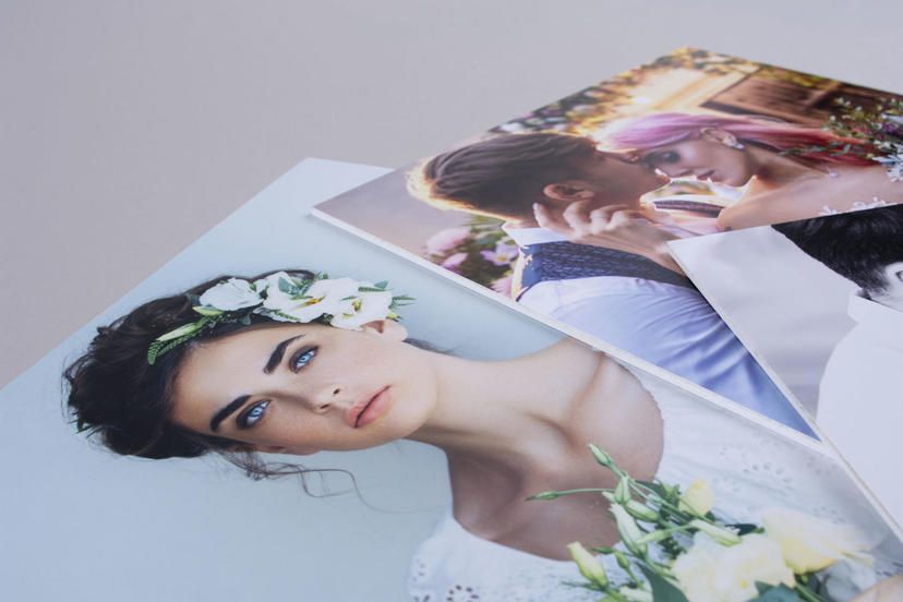 Close-up of wedding photos spread out showing printed professional photography.