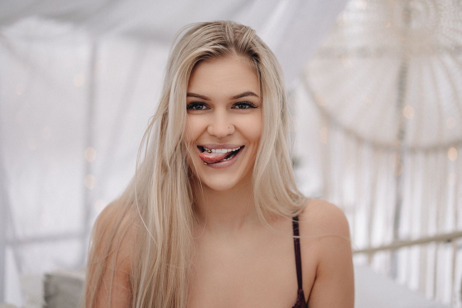 Bright indoor portrait with genuine smile against white backdrop.