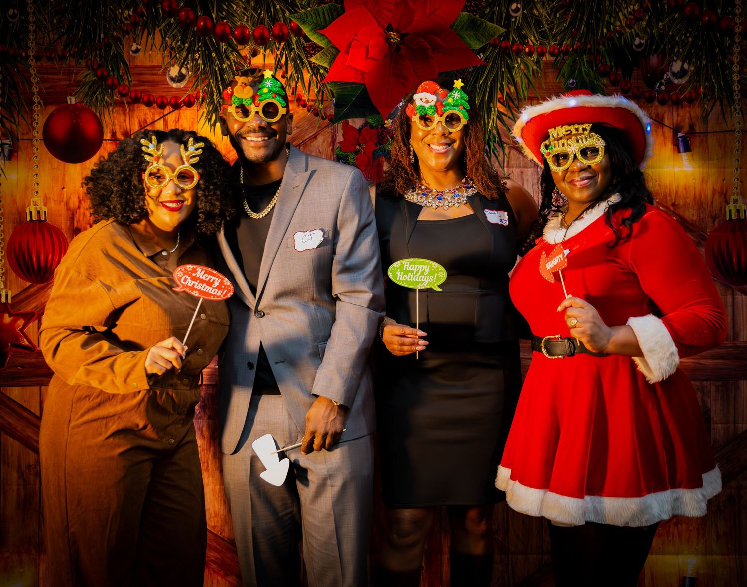 Group wearing festive attire and masks at holiday celebration with wooden backdrop.