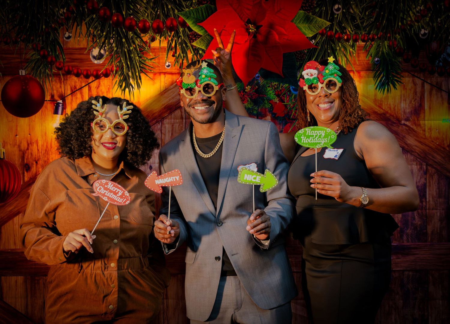 Three people with festive props and masks posing at holiday party.