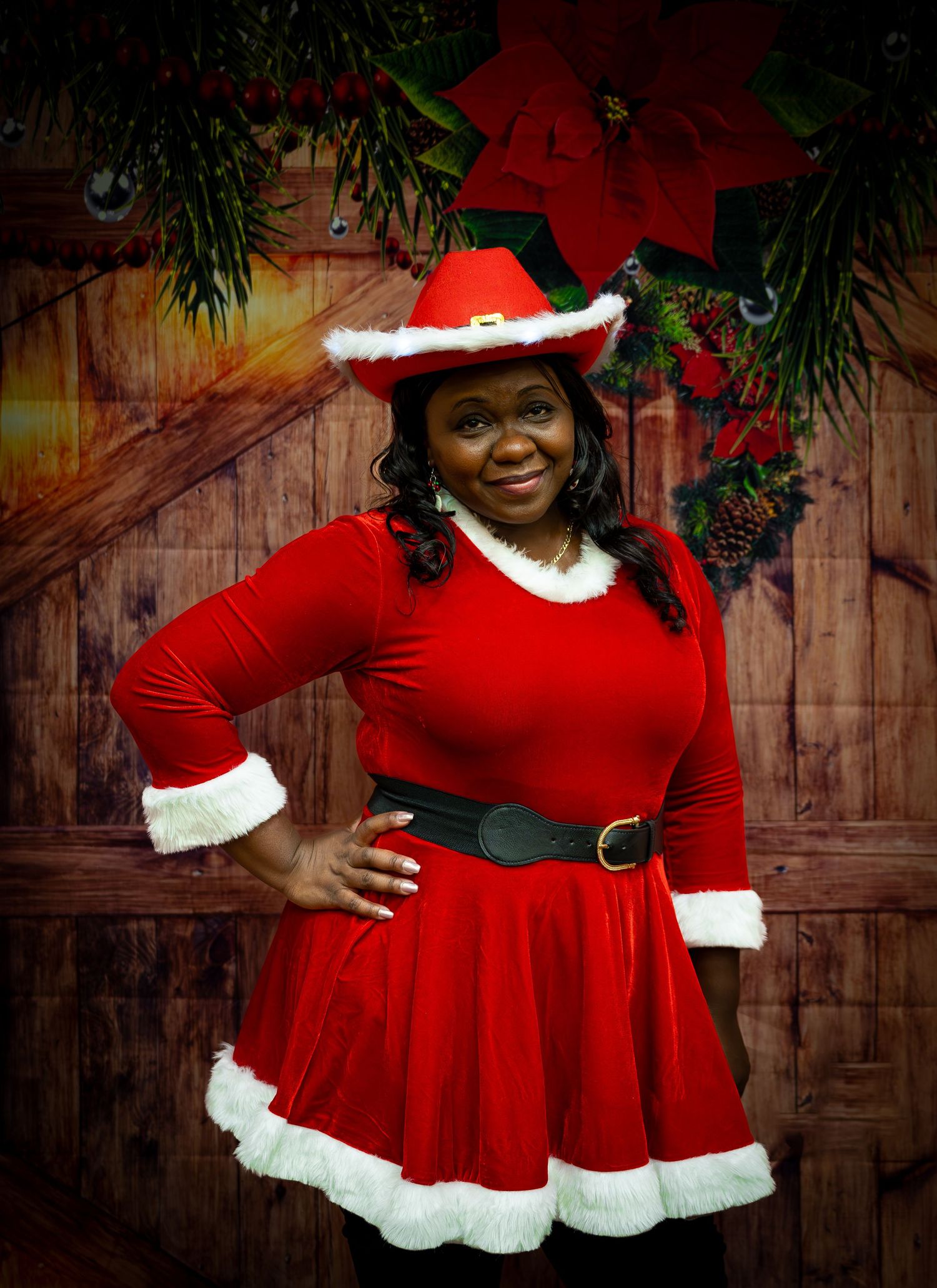 Festive portrait in Santa-style dress with white trim against holiday backdrop.