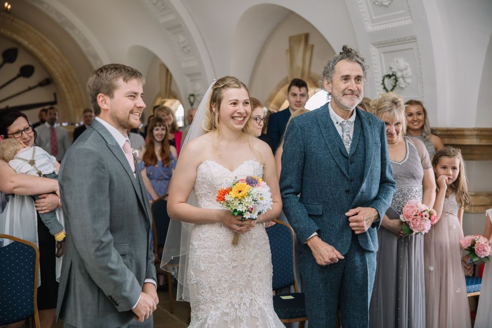 Wedding ceremony taking place in a beautiful venue with ornate architectural details.