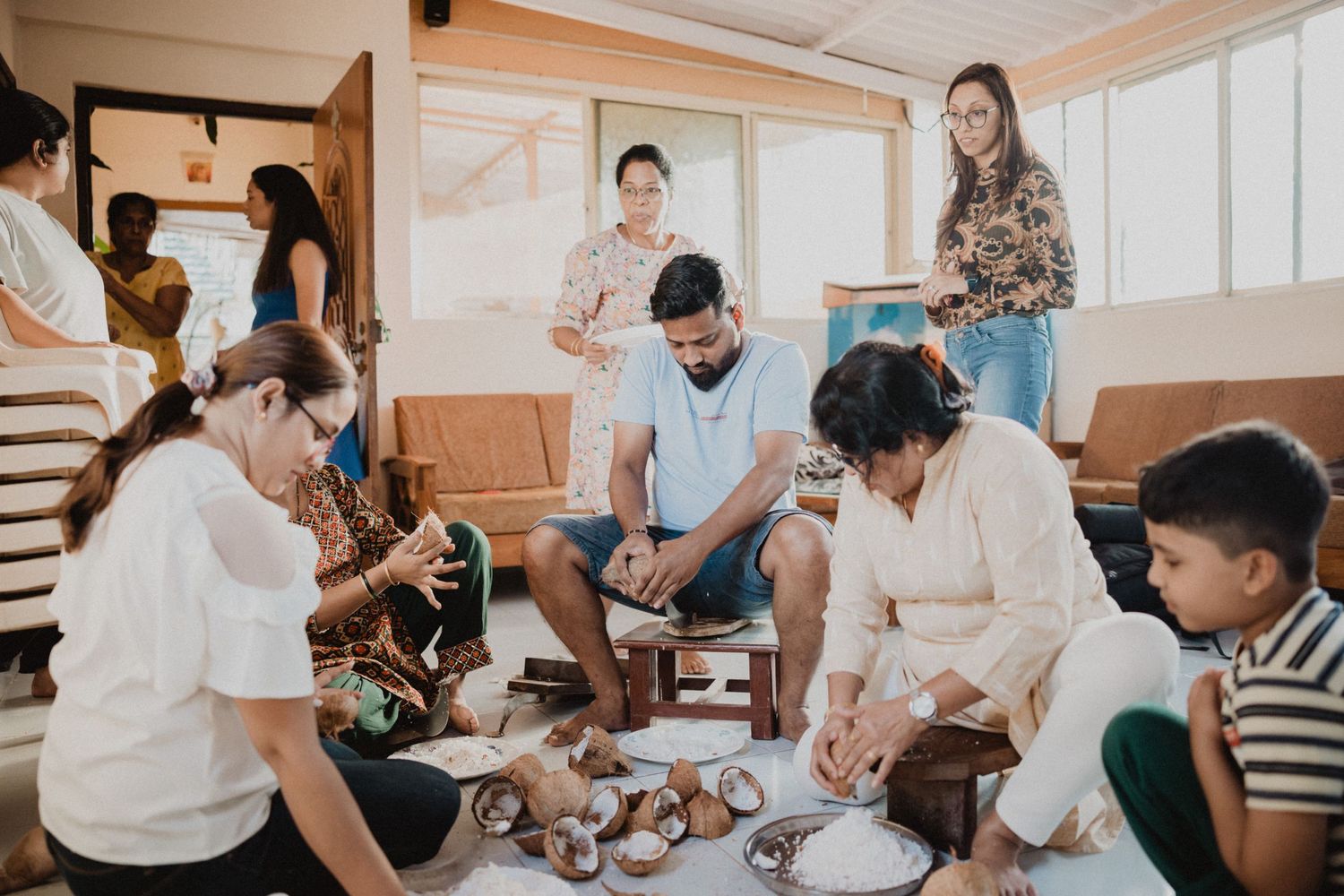 Group of people gathered in a bright indoor space for a casual social gathering.