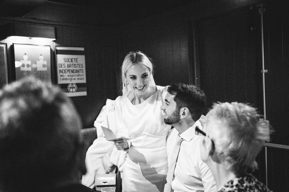Black and white photograph showing a lively gathering in what appears to be a pub or restaurant setting.
