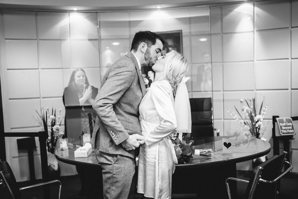 A romantic moment between a couple in a modern office setting.