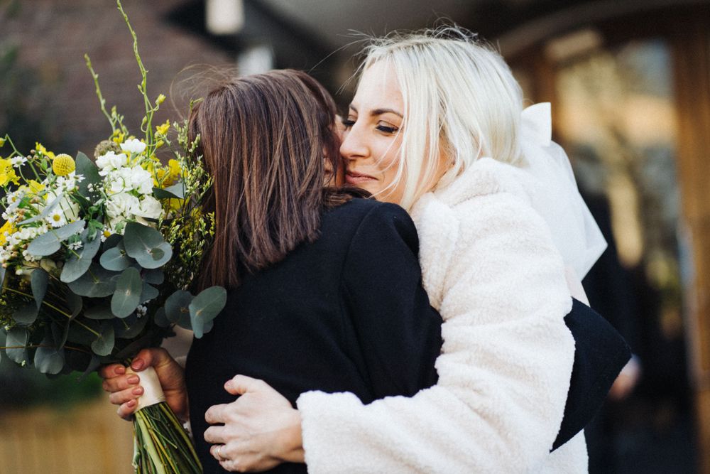 A heartfelt embrace shared between two people with a beautiful floral bouquet.
