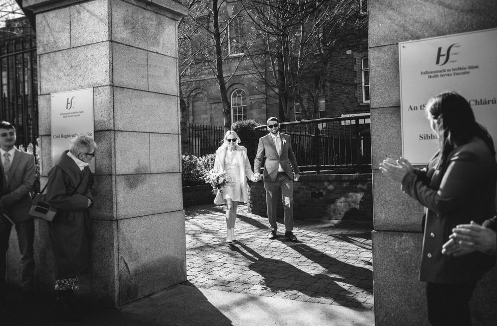 A group walking through stone pillars on a sunny winter day.
