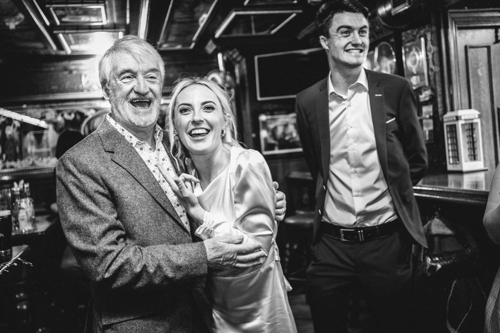 Black and white candid photo capturing a celebratory moment in a pub setting.