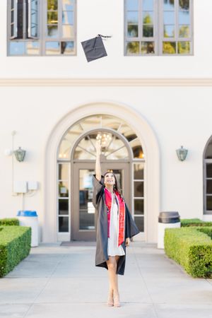 College graduate throwing up her cap into the air at University of San Diego