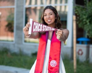 College grad holding a Chico State flag