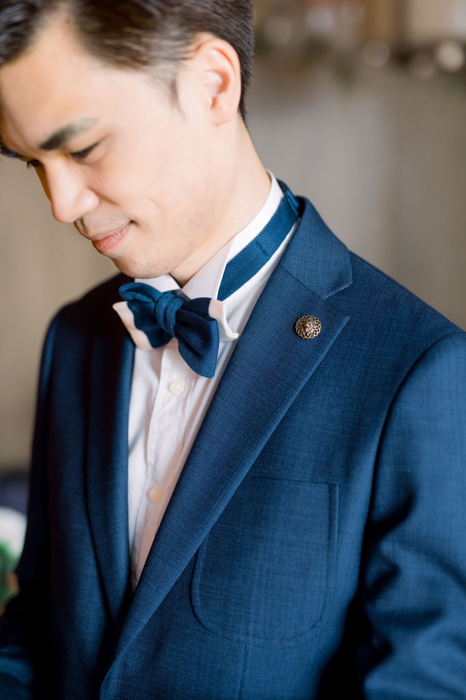 Close-up shots of groom in navy suit with bow tie showing subtle expressions.